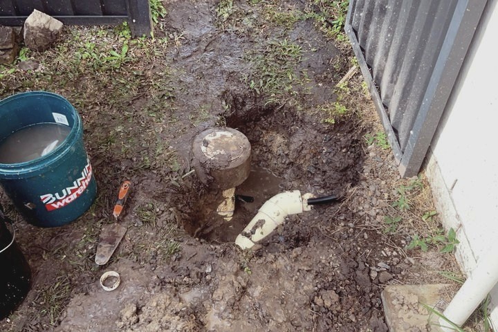Plumber locating a hidden water leak in a yard